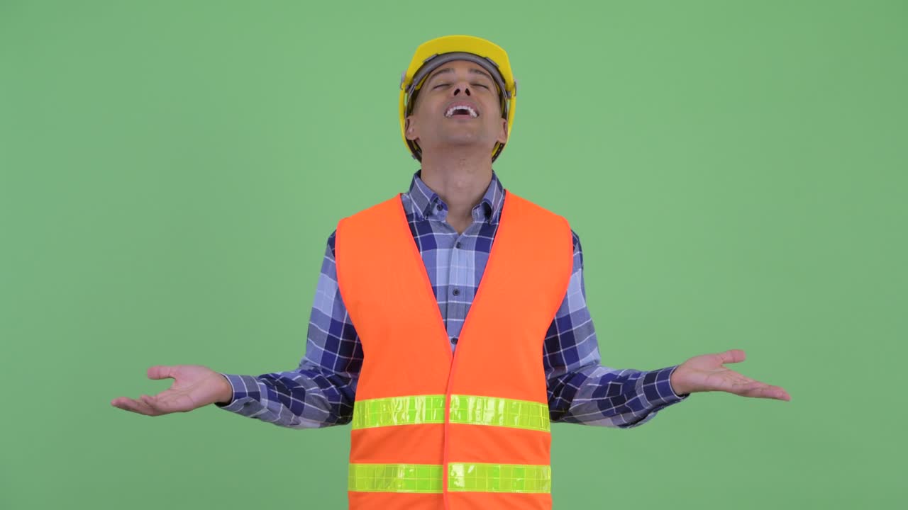 hombre multiétnico guapo trabajador de la construcción sonriendo con los ojos cerrados y gestando