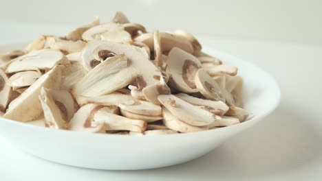 Frische-Champignons-In-Einer-Weißen-Schüssel-Auf-Dem-Tisch,