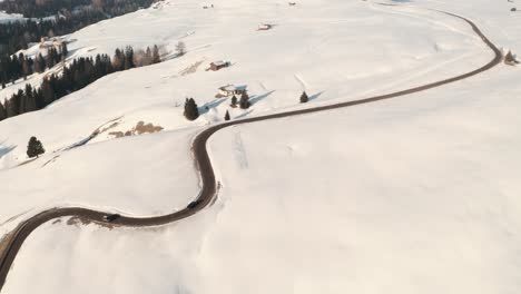 dolly back drone shot over snowy mountain road