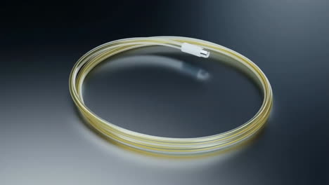 Coiled Yellow Charging Cable with White Connector on a Reflective Surface