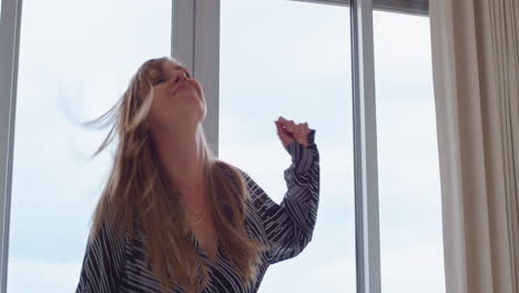 mujer feliz de viaje bailando en la habitación del hotel divirtiéndose celebrando las vacaciones de verano disfrutando de un estilo de vida de vacaciones despreocupado al amanecer