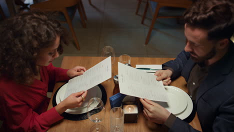 lovers looking restaurant menu on evening dinner date. romantic cafe concept.