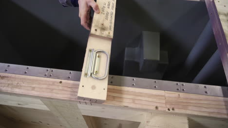 worker installing a part into a wooden crate