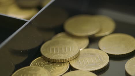 handheld shot of various euro coins neatly arranged in a cash register