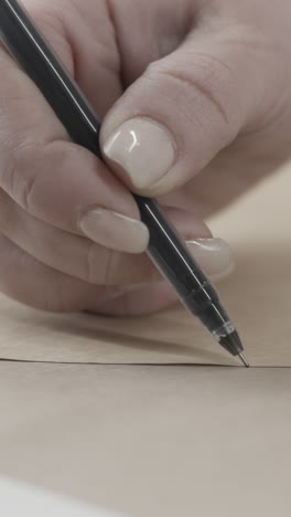 close-up of a hand holding a pen and writing on paper