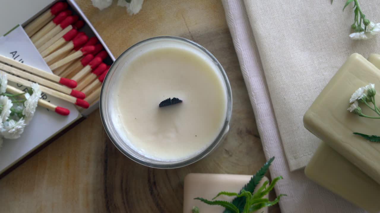 Close up of white candles and soaps on a wooden surface