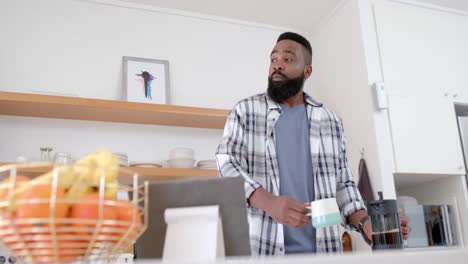 African-american-man-drinking-coffee-in-kitchen,-slow-motion