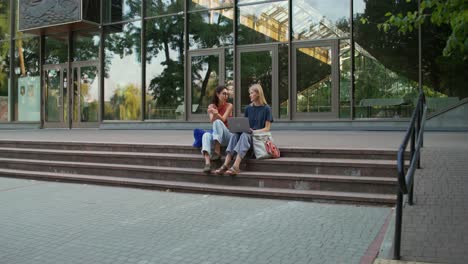 two women discussing on campus stairs