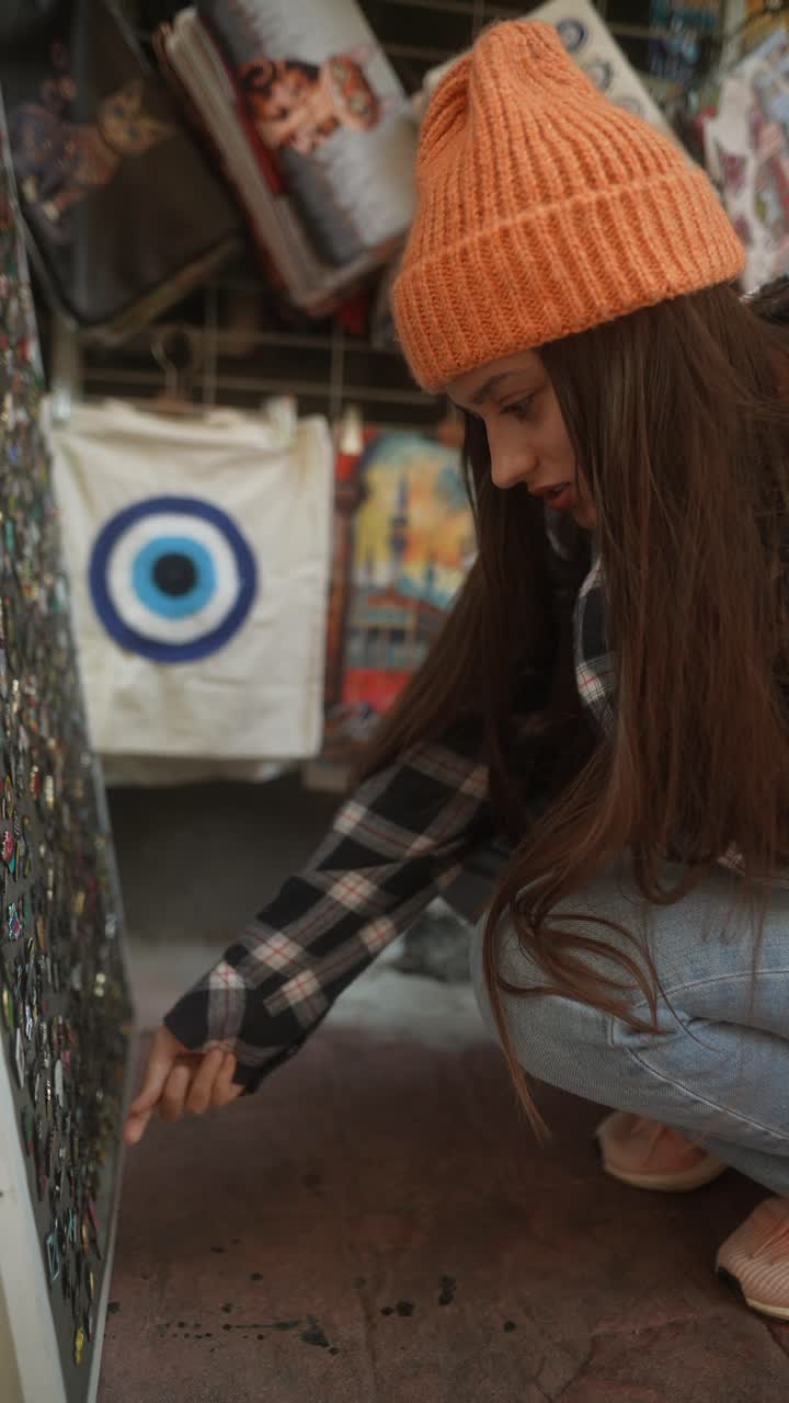 joven mirando alfileres en una tienda de recuerdos