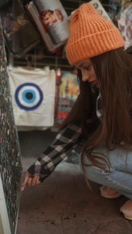 young woman looking at pins in a souvenir shop