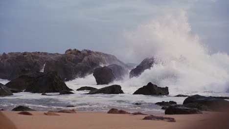 Majestuosas-Olas-Rompen-En-Serenas-Rocas-De-Playa