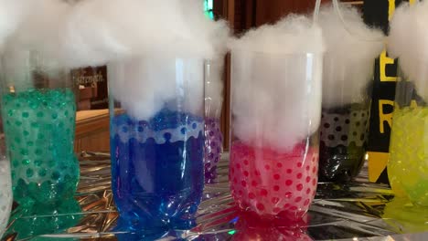 fondo de laboratorio de ciencia para niños hecho de botellas de refresco de 2 litros cortadas por la mitad llenas de cuentas de agua de diferentes colores