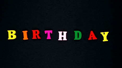 la palabra "cumpleaños" está formada por letras de madera multicolores. palabras coloridas en bucle.