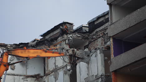 breaking off the walls of the building with the help of demolishing machinery. dismantling the building ruined by the natural disaster.