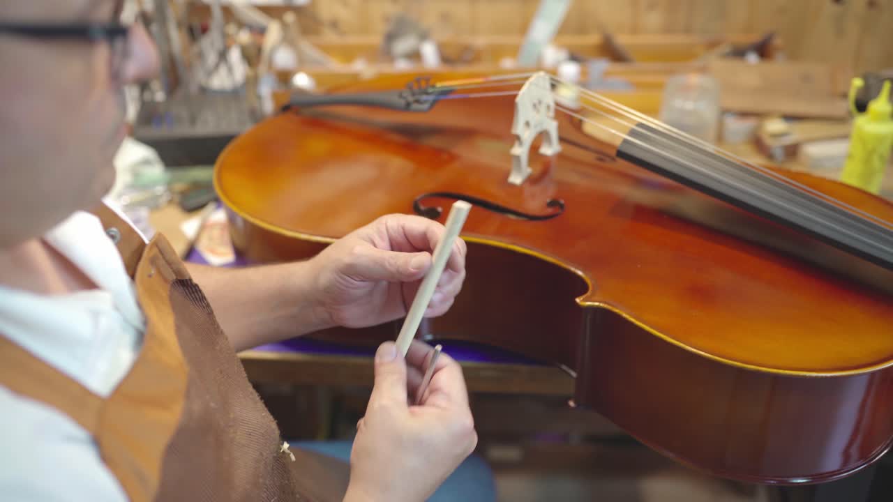 Luthier installing sound post to violin