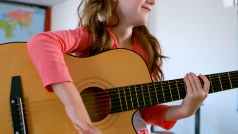 Mittelteil-Einer-Kaukasischen-Schülerin,-Die-Auf-Einem-Schreibtisch-Sitzt-Und-In-Einem-Klassenzimmer-Gitarre-Spielt,-4K