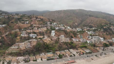 aerial low push-in shot of burned and surviving homes at las flores canyon after the palisades wildfire in malibu, california. 4k at 30 fps