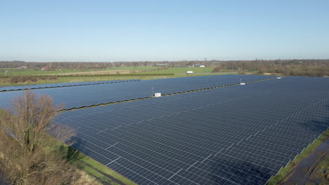 Blick-Aus-Der-Vogelperspektive-Auf-Ein-Großes-Solarfeld-In-Einer-Ländlichen-Gegend-Mit-Einem-Weißen-LKW,-Der-Im-Hintergrund-Fährt