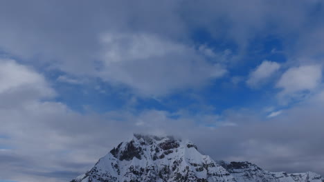 Panorámica-Aérea-Lenta-Hacia-Abajo-De-La-Cima-Cubierta-De-Nieve-Del-Nevado-Auzangate-En-Perú.