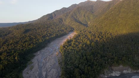 Braided-riverbed-in-lush-mountainous-landscape-at-sunset
