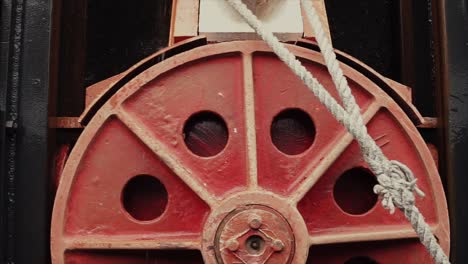 close-up of a red pulley with rope