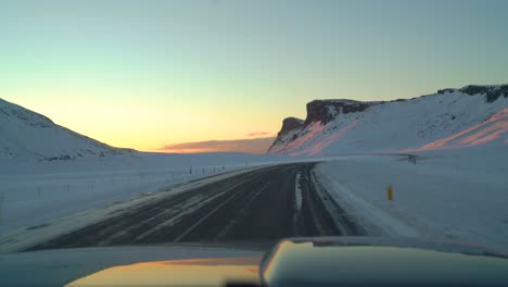 Driving-on-icy-roads-in-Iceland-in-the-winter-towards-the-sunrise-in-February