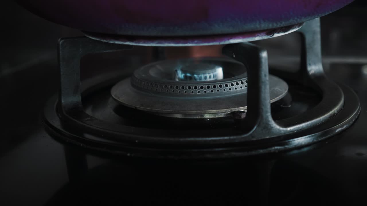 부에서 파란색과 빨간색으로 불타는 불꽃이 있는 검은색 가스 스토브의 비디오