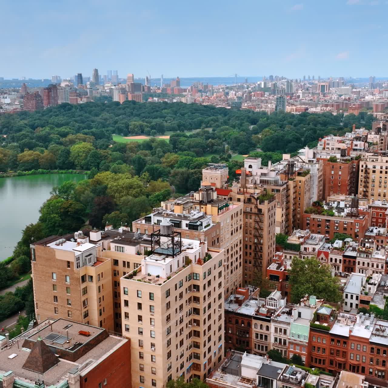 Part of the Central Park surrounded by multiple buildings. Sight of New York from top on day time