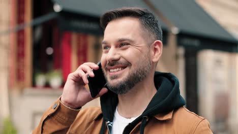 Caucasian-man-with-beard-talking-on-the-phone-in-the-street