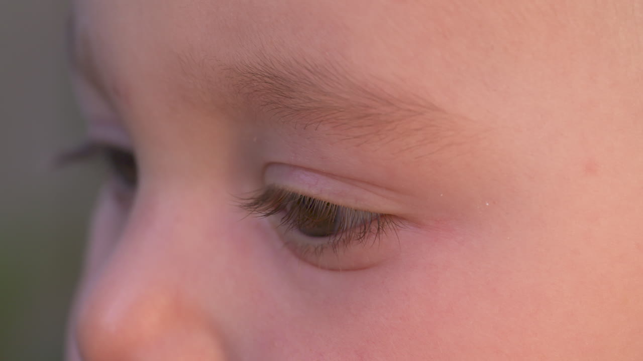 vista lateral macro de los ojos de un bebé mirando alrededor, cámara lenta