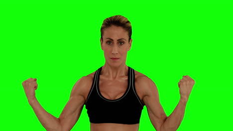 una mujer súper en forma flexionando sus brazos.
