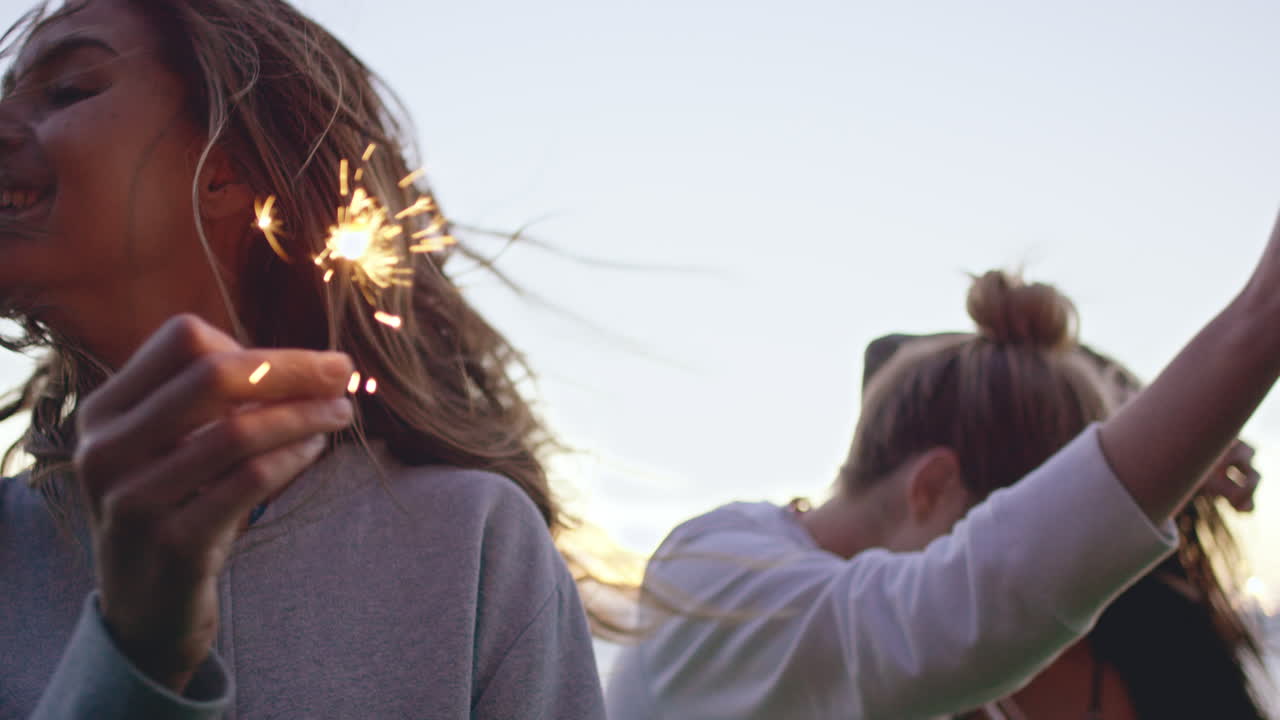 adolescentes celebrando y riendo con bengalas brillantes.