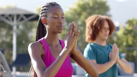 focused diverse friends practicing yoga meditation together sitting in sunny garden, slow motion