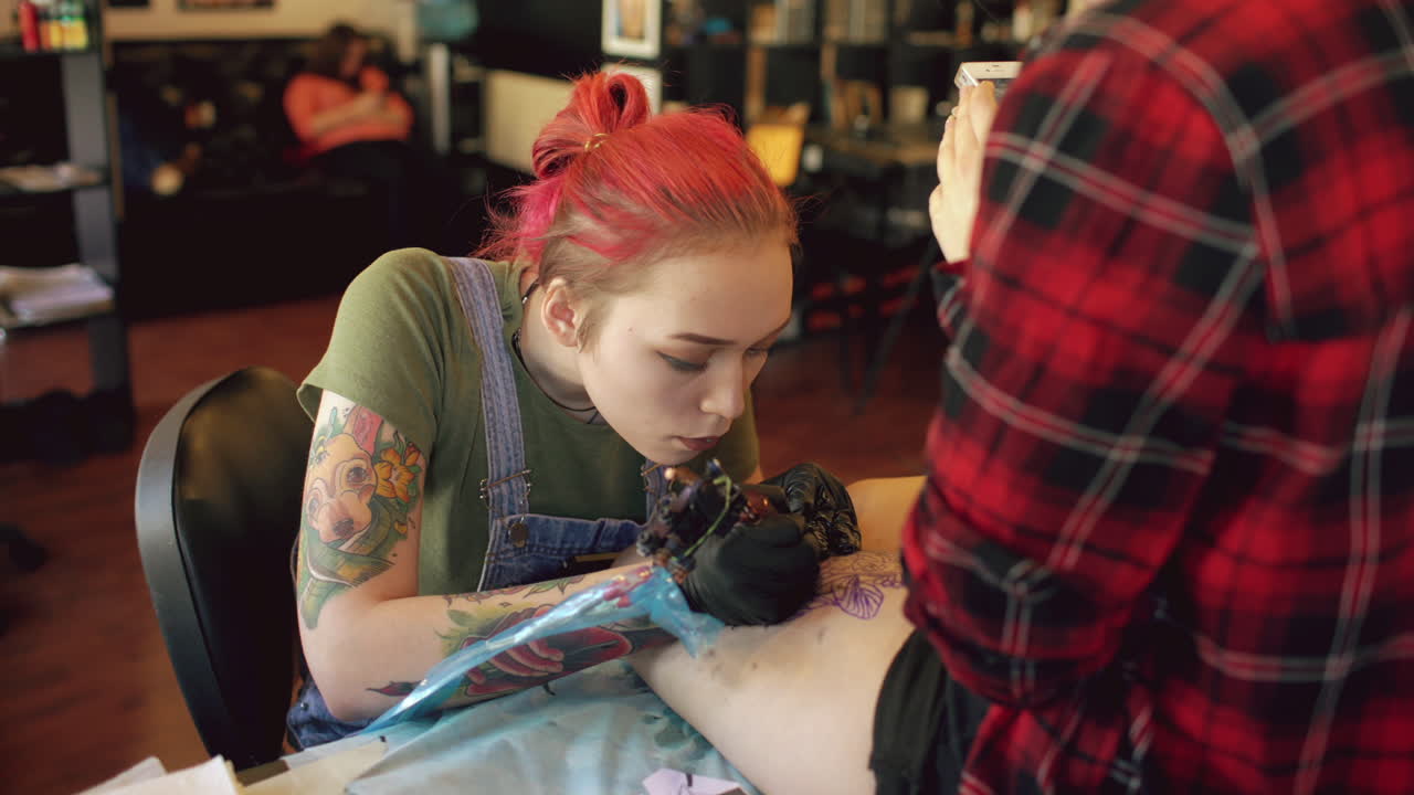 Tattoo Artist Working on Client's Leg