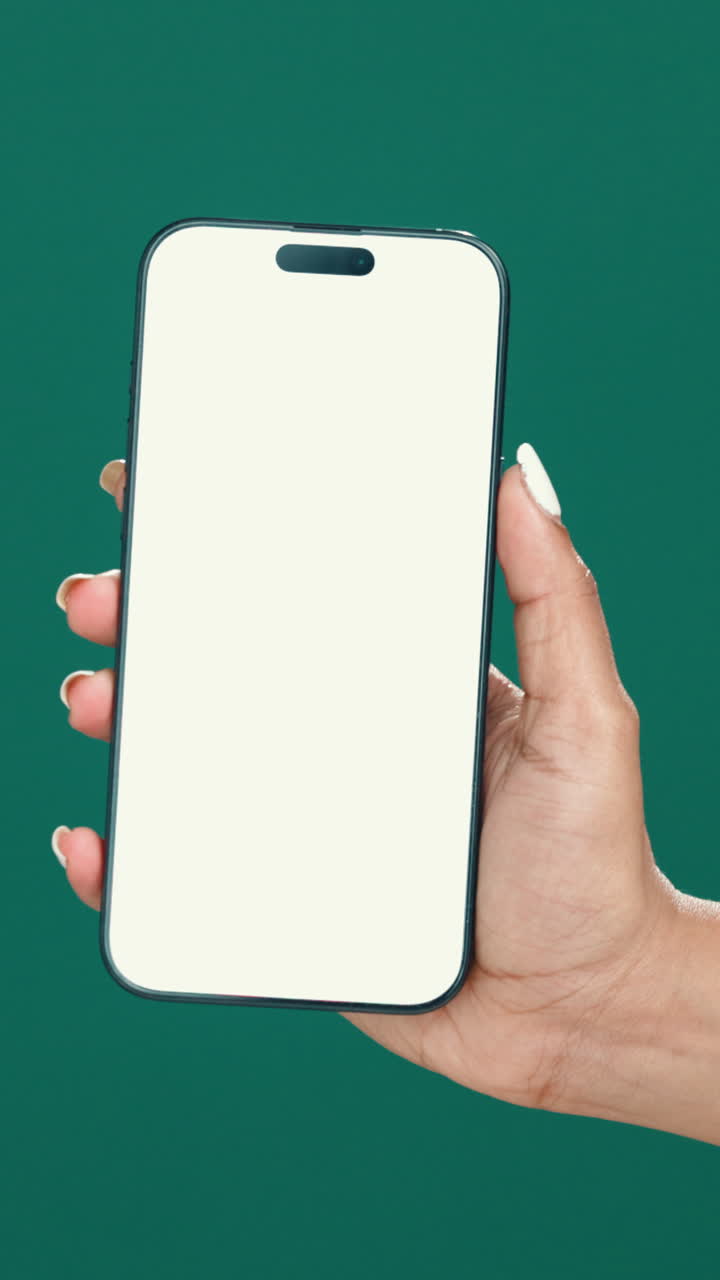 Mano che tiene uno smartphone con schermo bianco vuoto su sfondo verde