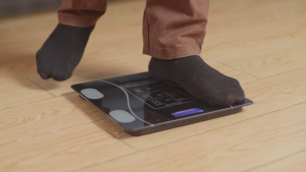 primer plano de un hombre gordo pesándose en casa