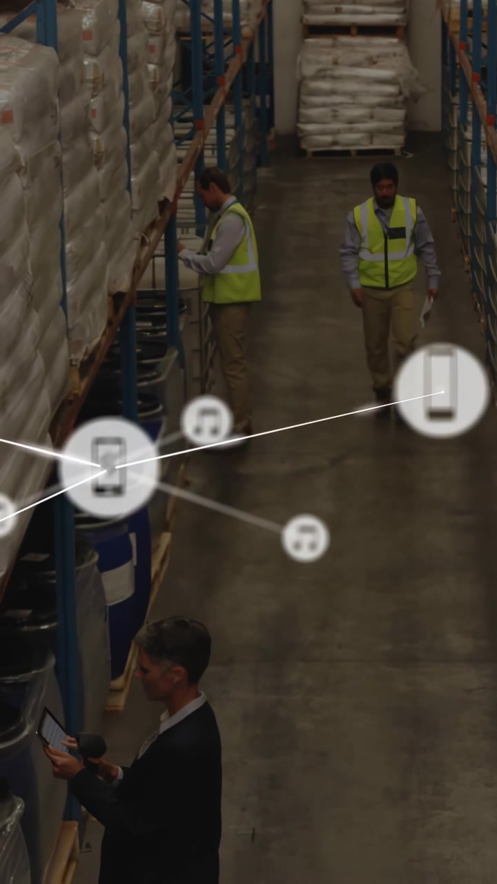 Video verticale: Responsabile che tocca un tablet creando icone sul personale che scansiona le scorte in magazzino per un audit.