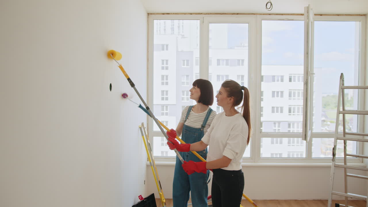 dos mujeres pintando una pared