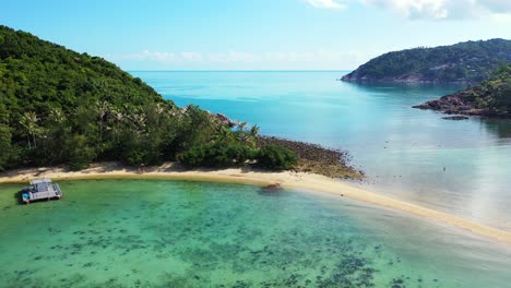 Paradise-shore-of-tropical-islands-with-rocks-and-white-sand-washed-by-calm-turquoise-lagoon-with-coral-reefs-in-Thailand