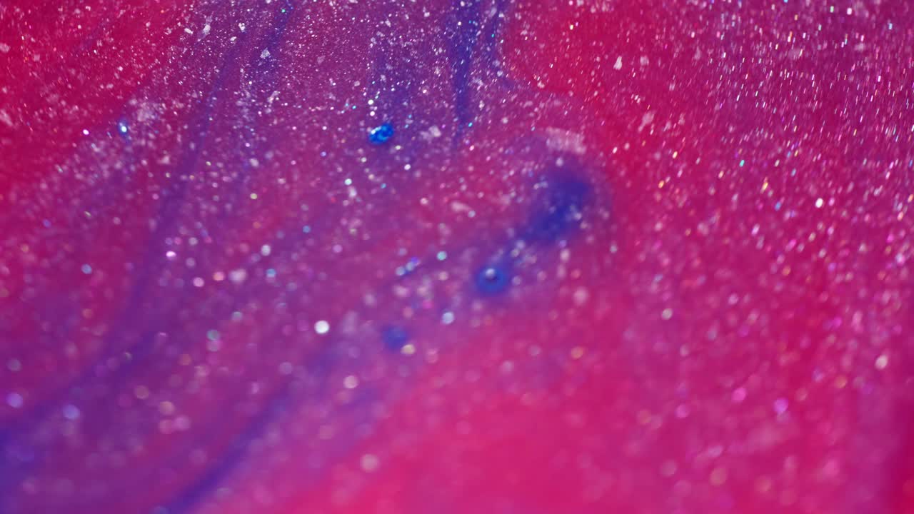 Abstract ink mixing, macro shot with glittery paint details and vibrant colors blending