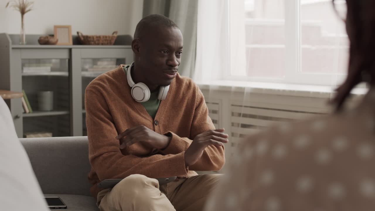 African Man Talking to Unrecognizable Woman Indoors