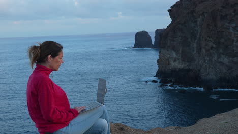 freelancer working with laptop on a cliff in gran canaria, canary islands, spain. slow motion video