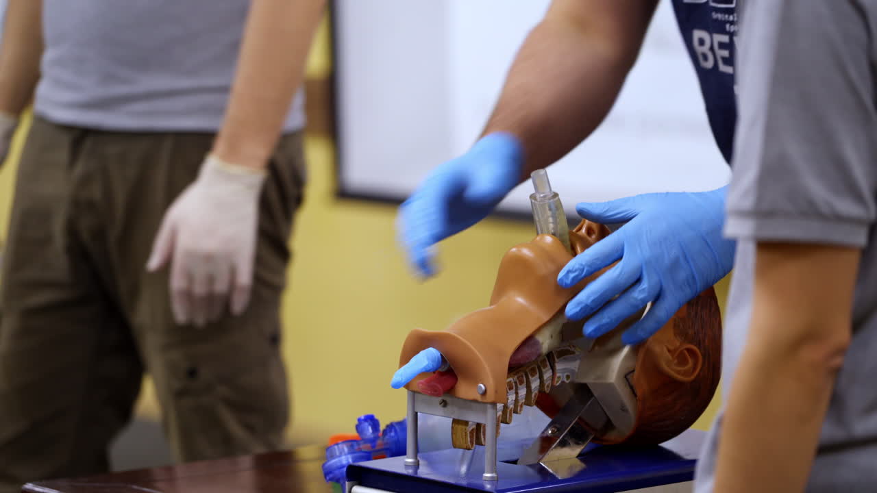 Training course on dummy head. Practitioner in medical gloves performing a resuscitation procedure on a manikin. Practical skills.