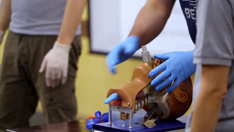 training course on dummy head. practitioner in medical gloves performing a resuscitation procedure on a manikin. practical skills.