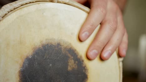 close up of hands of a man playing a drum.