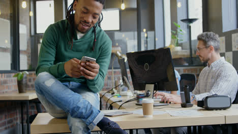 smiling male executive using mobile phone at desk in office 4k