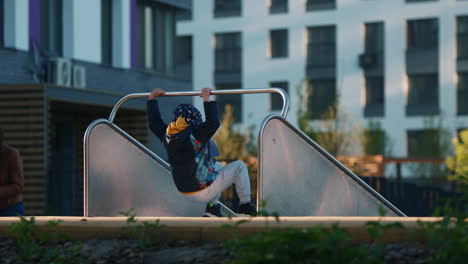 child on a metal slide in an urban park