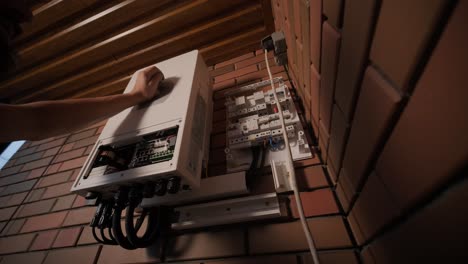 an electrician installing an inverter in a home. the image shows technical skill, modern tools, and attention to safety in electrical work