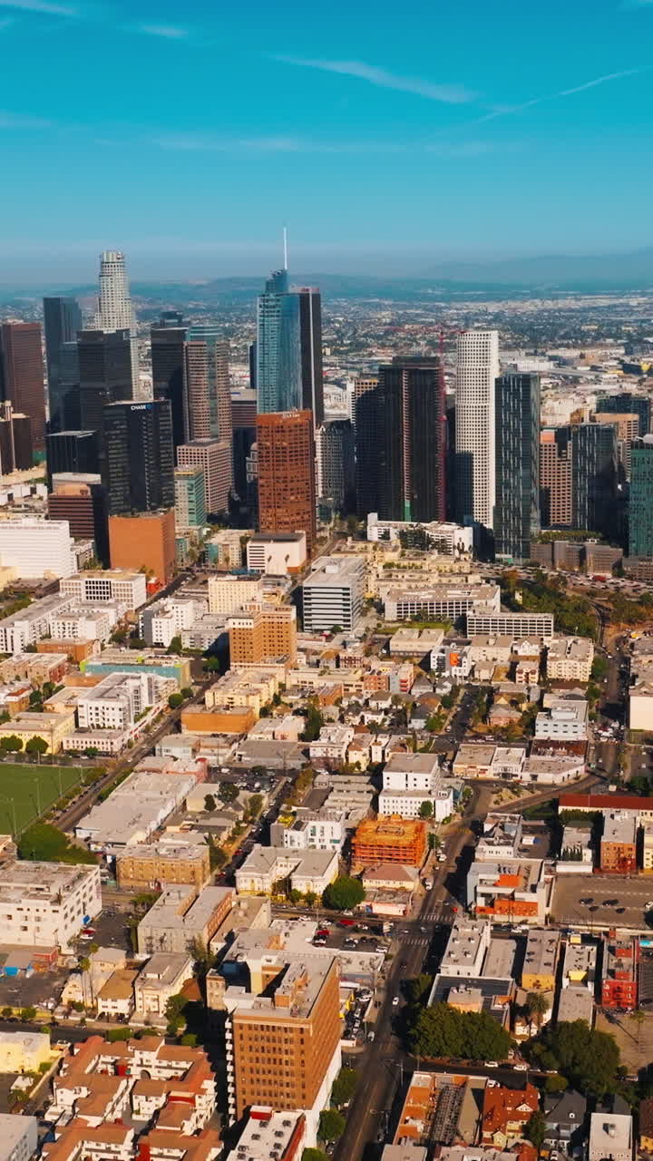 Beautiful sunny view of Los Angeles downtown. A cluster of modern skyscrapers amidst the low urban cityscape. Top view. Vertical video