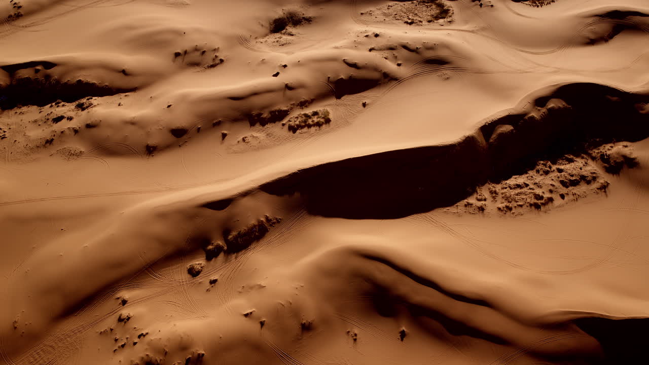 Dreamlike drone view capturing the flowing lines and textures of Pink Sand Dunes State Park.